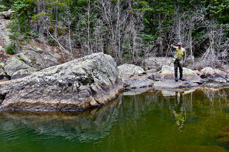 An angler fishing a deep pool with a Euro Nymphing setup on Colorado's Eagle River with rocks and trees in the background.
