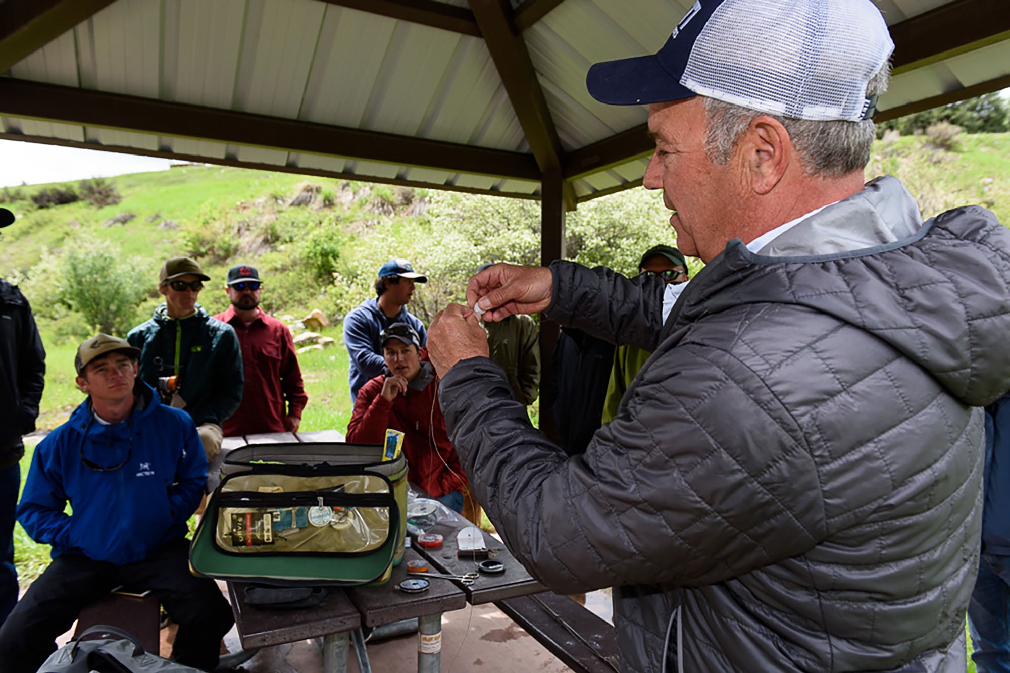A Vail Valley Anglers Guide teaching a group of students how to setup a fly fishing rod.